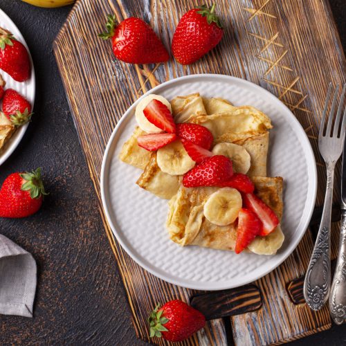 Pancakes crepes with sliced strawberry and banana